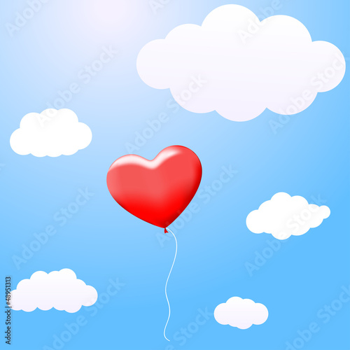 Balloon in the shape of a heart flying in the clouds