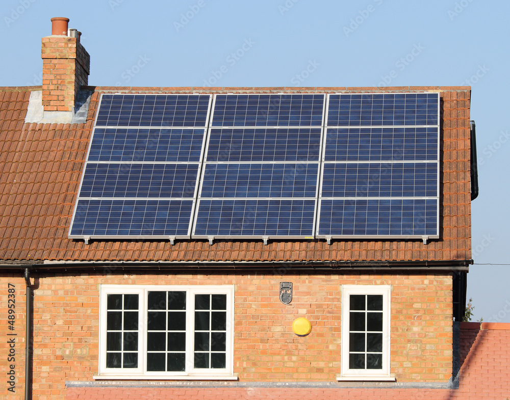 Fototapeta premium Solar photovoltaic panel array on a tiled house roof