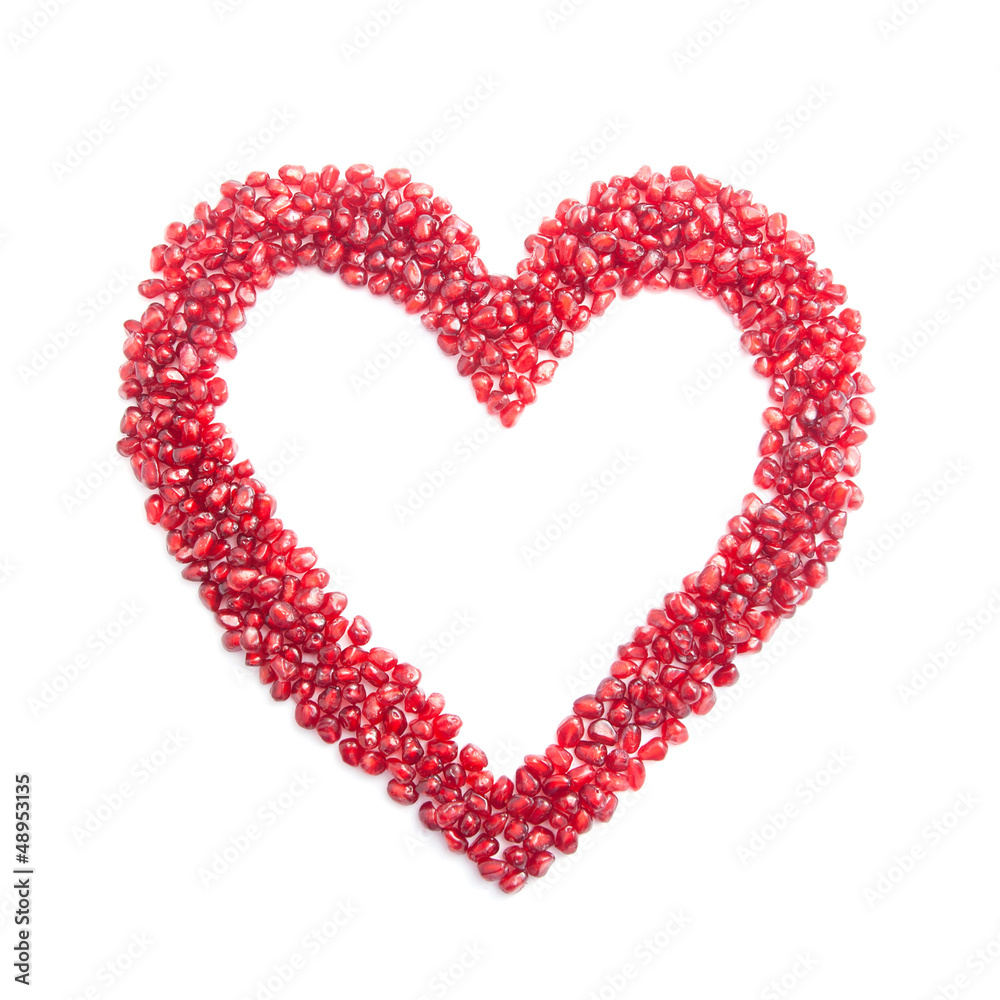 ripe pomegranate seeds in form of heart isolated on white backgr