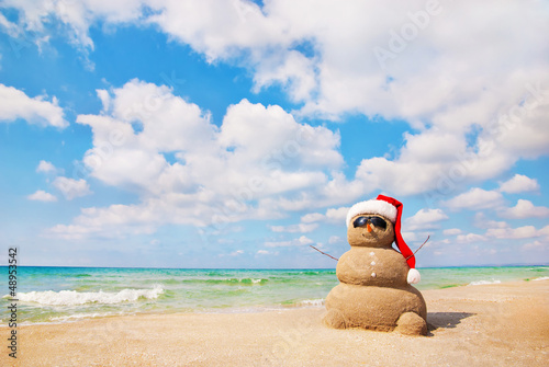Sand snowman in santa hat. Holiday concept can be used for New Y