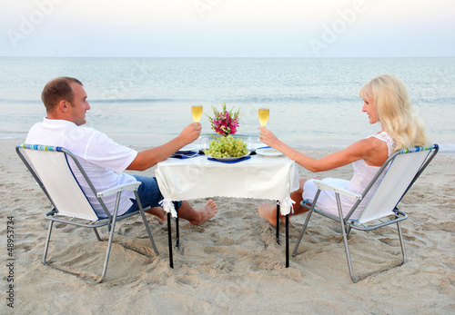 A young couple share a romantic dinner with candles and wine gla