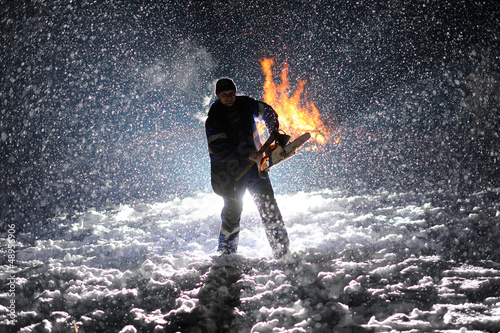 man with chainsaw in the hands on the night snow background photo