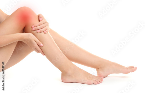Woman holding sore leg  isolated on white