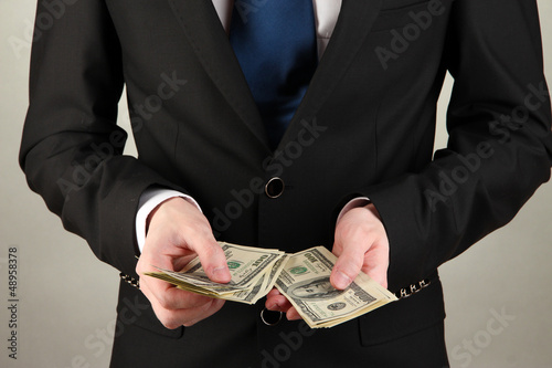 Wallpaper Mural Business man counts money on grey background Torontodigital.ca