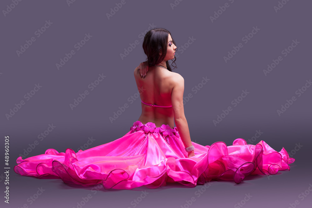 Dancer in pink costume sitting on floor