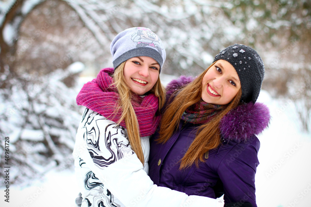 Two happy young girls having fun in winter park outdoors Two happy young girls having fun in winter park outdoors