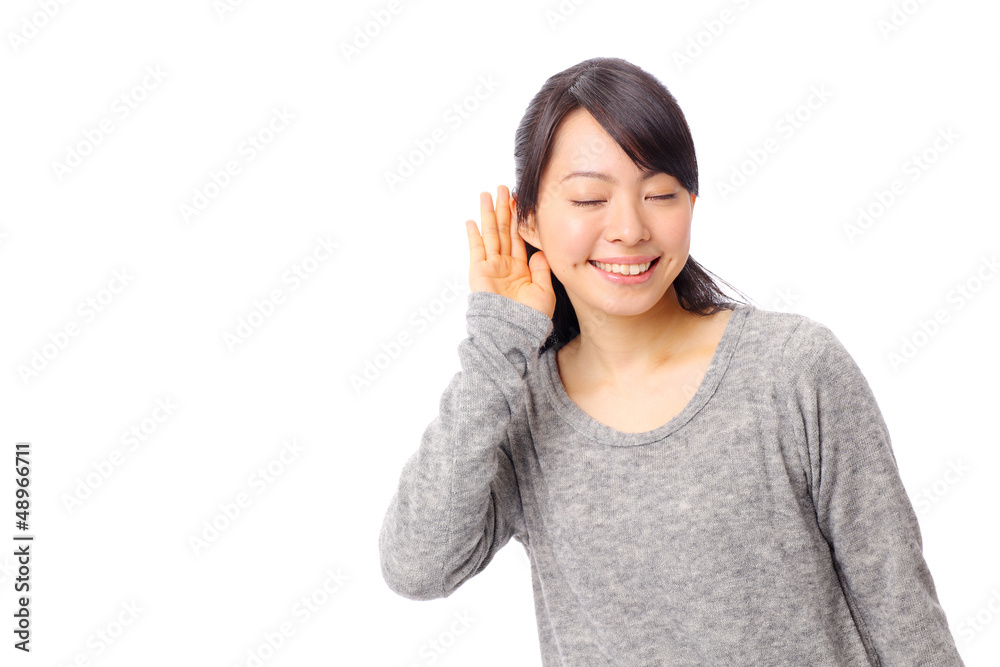 耳に手を当てて聞く女の子