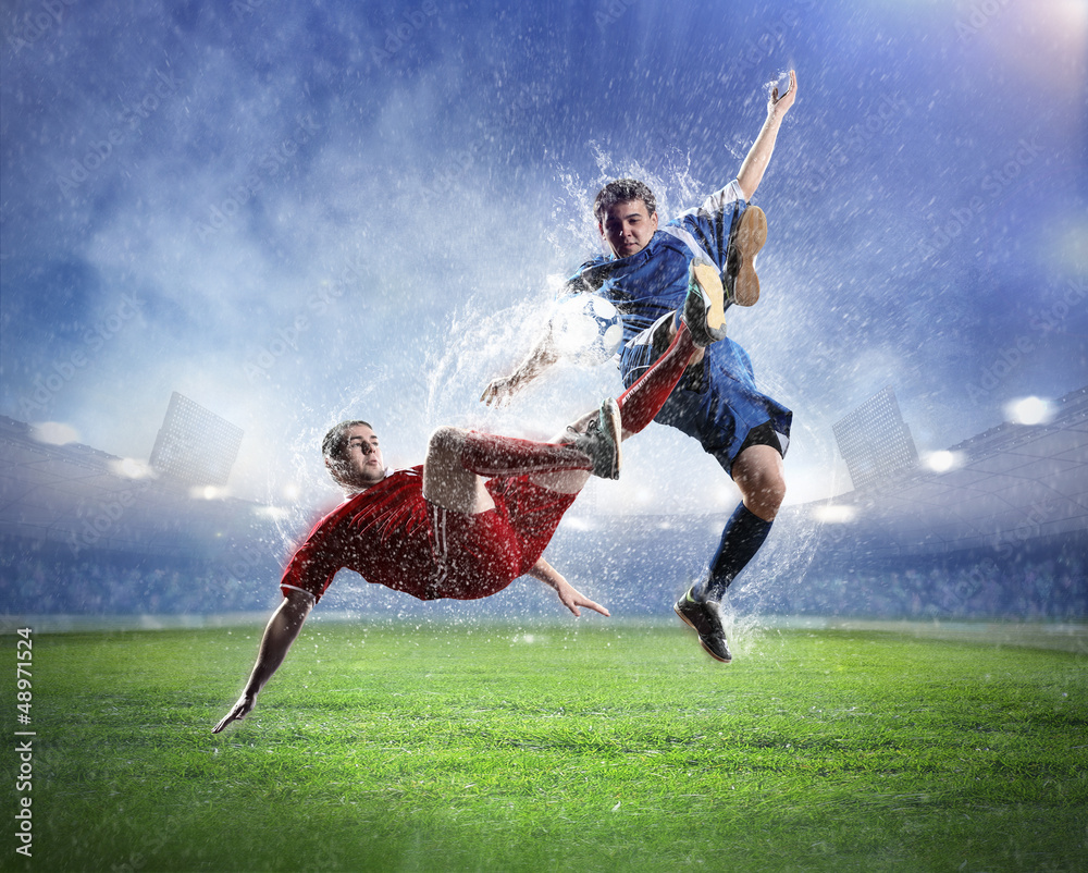 two football players striking the ball two football players striking the ball