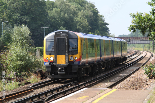UK commuter train passing station platform
