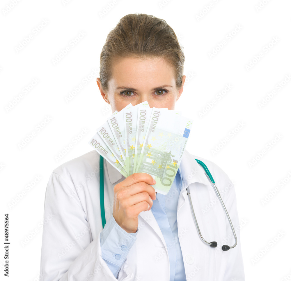 Medical doctor woman hiding behind fan of euros