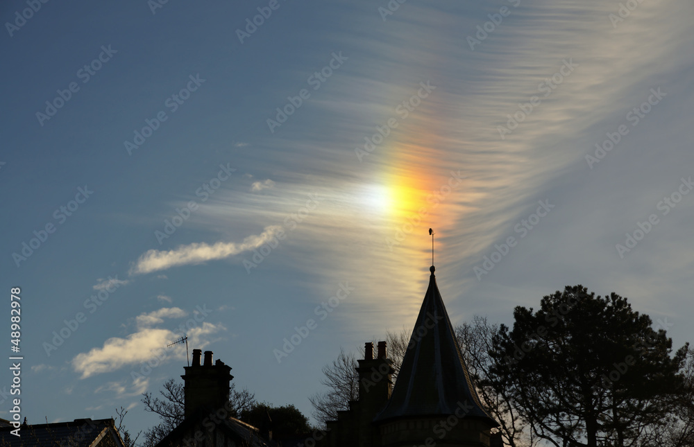 Sun dog and cirrus cloud above a church.