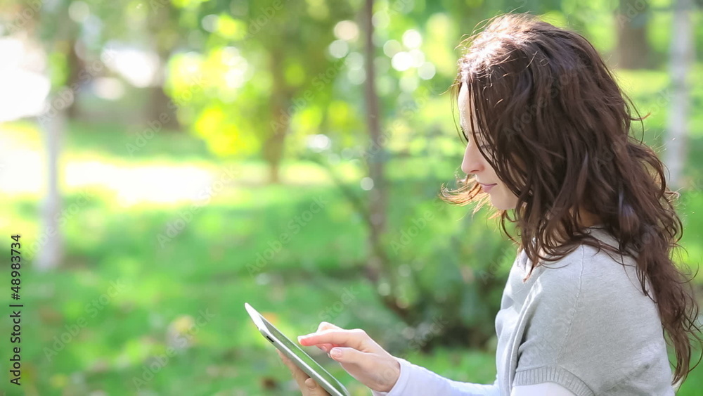 Young woman using tablet PC in spring park