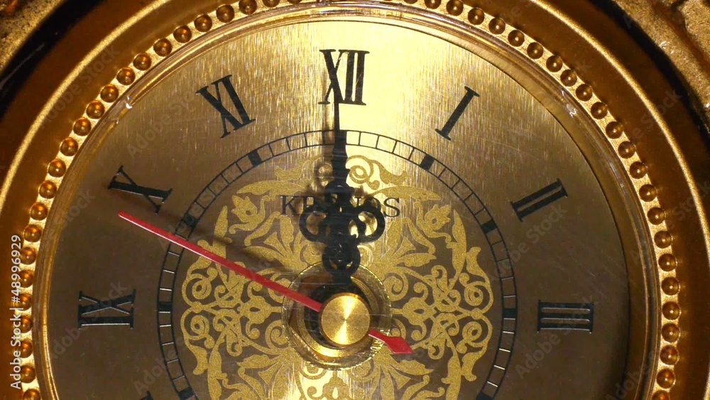 The arrows of the antique clock show 12:00. Clode-up shot.