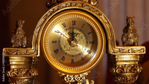 The arrows of the antique clock show 12:00.