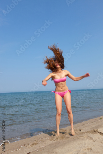 Happy Woman Jumping on the Beach at Seaside