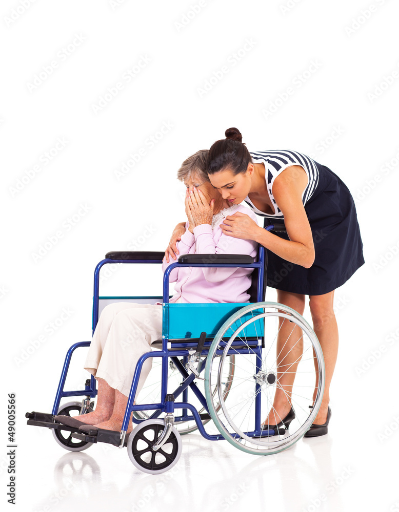 caregiver hugging and comforting lonely disabled senior woman