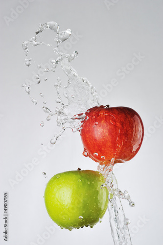 Red, green apples and water splash