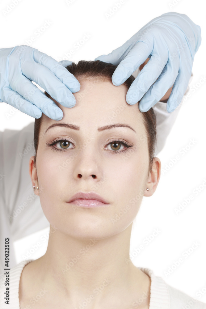  Arzt überprüft das Gesicht der Patientin vor dem Eingriff