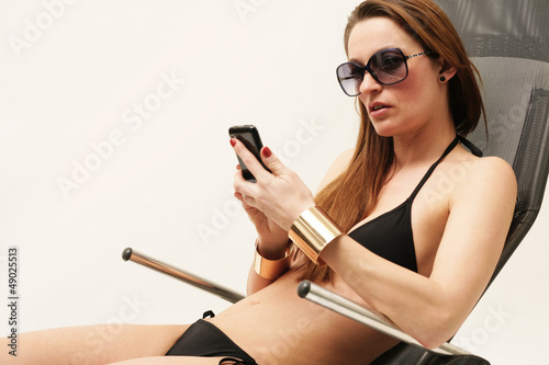 Frau im Bikini mit Handy