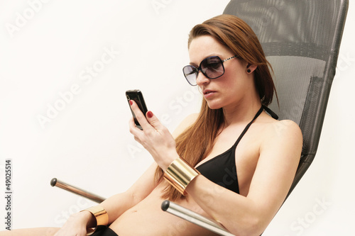 Frau im Bikini mit Handy