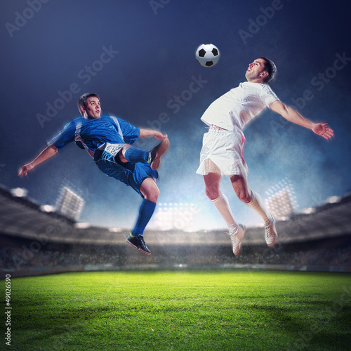 two football players striking the ball