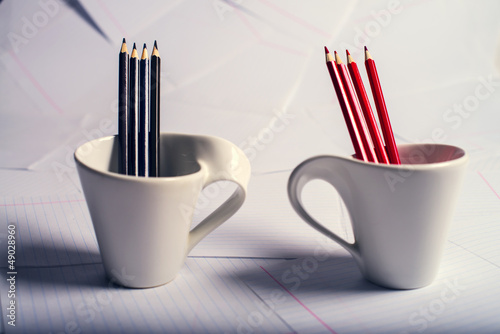 black and red pencils stand in two cups