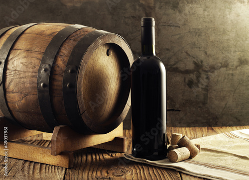 Red wine bottle and old barrel