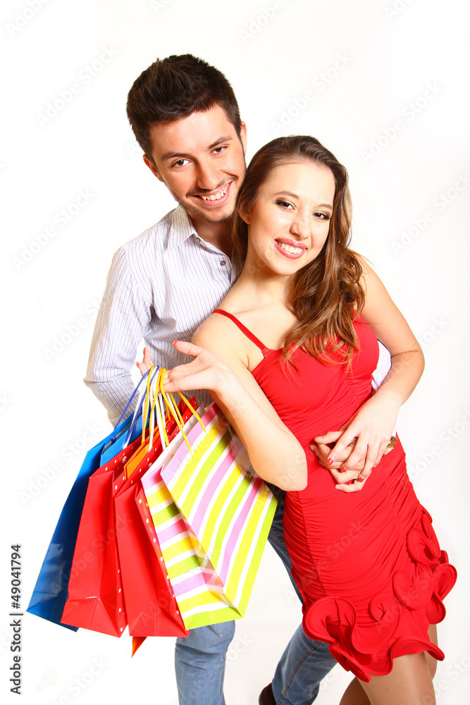 Young couple with shopping bags hugging isolated on whitea backg Young couple with shopping bags hugging isolated on whitea backg