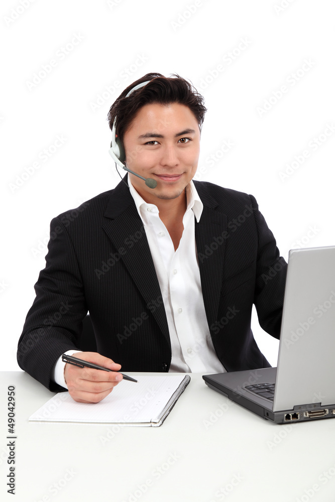 Young man working, with a laptop and headset Young man working, with a laptop and headset