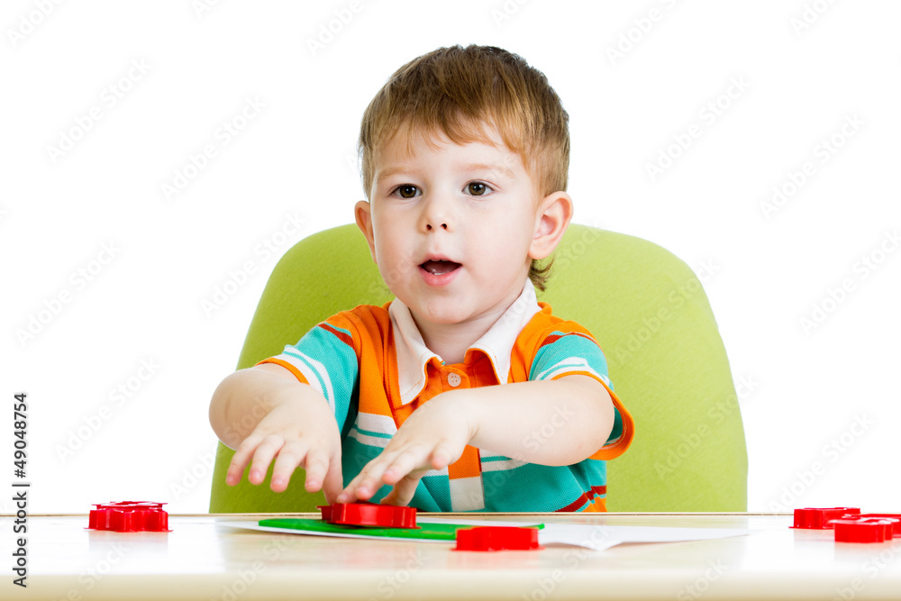 kid boy sitting at table and playing with colorful clay toy kid boy sitting at table and playing with colorful clay toy