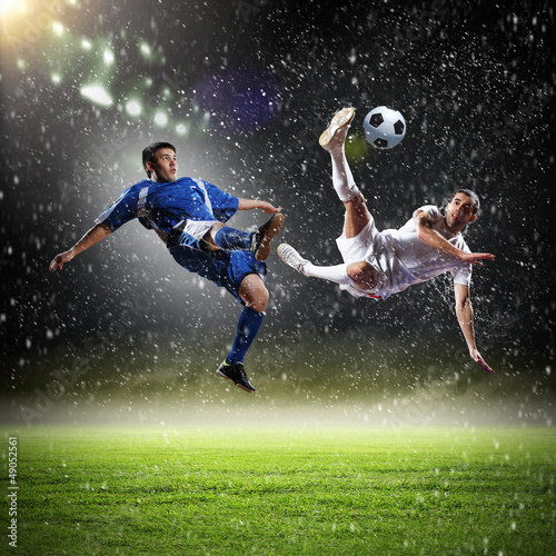 two football players striking the ball photo