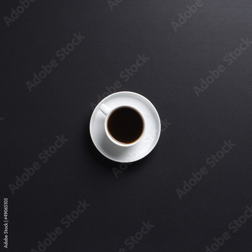 A beautiful white cup of coffe on a black table background