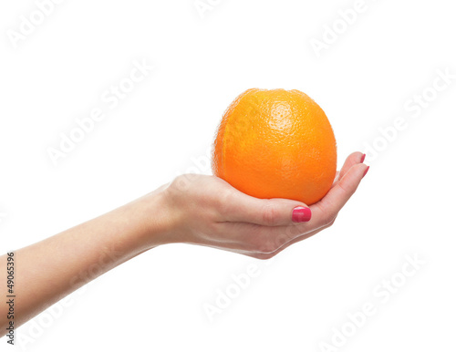 A fresh and tasty orange held in a female hand on white