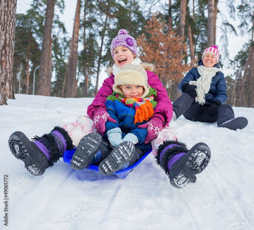 фотографія Funny family is sledging in winter-landscape