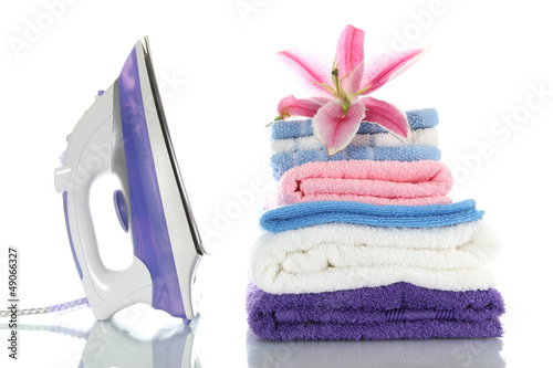 Fototapeta Naklejka Na Ścianę i Meble -  Pile of clothes with lily and electric iron, isolated on white