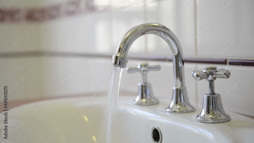 Water running from a chrome tap faucet Water running from a chrome tap faucet