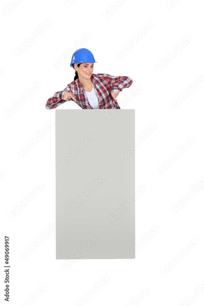Female builder stood with poster Female builder stood with poster
