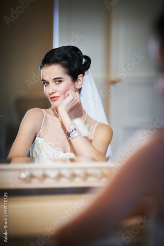Beautiful bride sitting near mirror