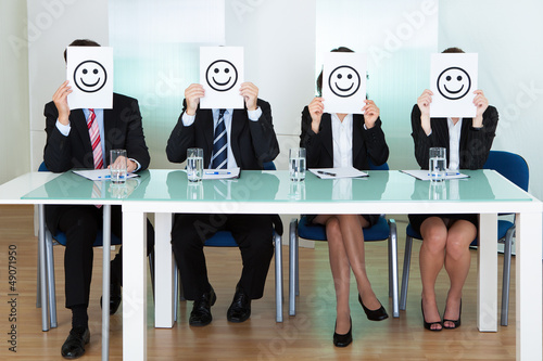 Row of business executives with smiley faces