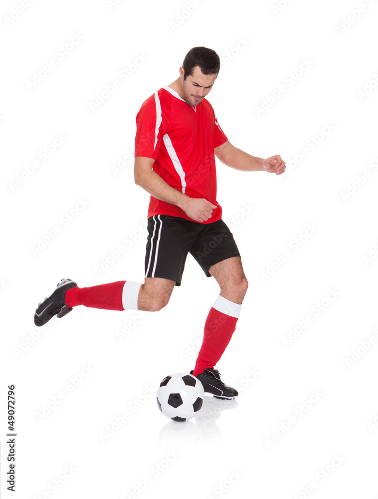 Professional soccer player kicking ball