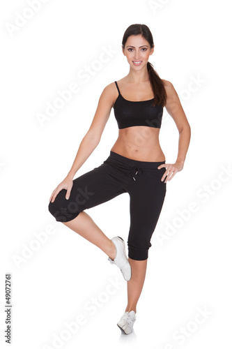 Young Woman Exercising While Standing On One Leg