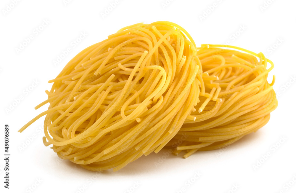 Italian egg pasta fettuccine nest isolated on white background Italian egg pasta fettuccine nest isolated on white background