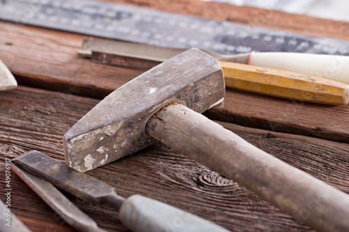 Dirty set of hand tools on a wooden panel