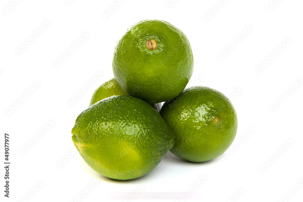 Group of whole limes and one half lime on white Group of whole limes and one half lime on white