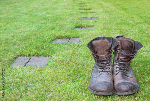Worn boots next to a path