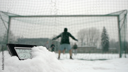 determined soccer players in winter time thermometer in foregrou photo