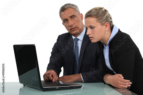 businessman and businesswoman analysing data on their laptop