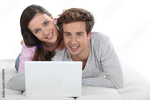 Young couple posing with their laptop