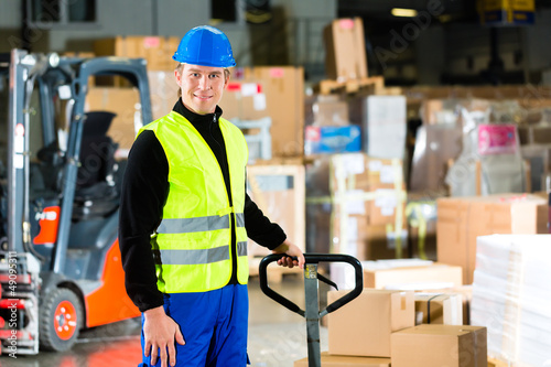 Storeman with mover at warehouse of forwarding photo