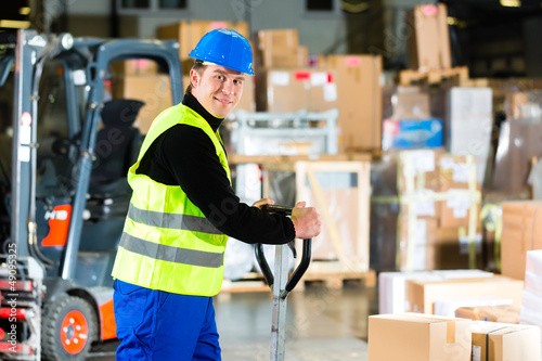 Storeman with mover at warehouse of forwarding photo